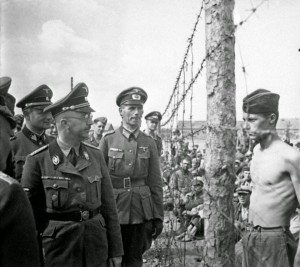 HeinrichHimmler,chefe das SS, visita campo de concentração de prisioneiros. Usa uniforme e insígnias semelhante as que são vendidas na Internet hoje em dia. (Foto: Todo História)